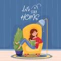 Caption let`s stay home, girl reads book on armchair near home flower, light lamp and a carpet. Blue wall background wooden floor
